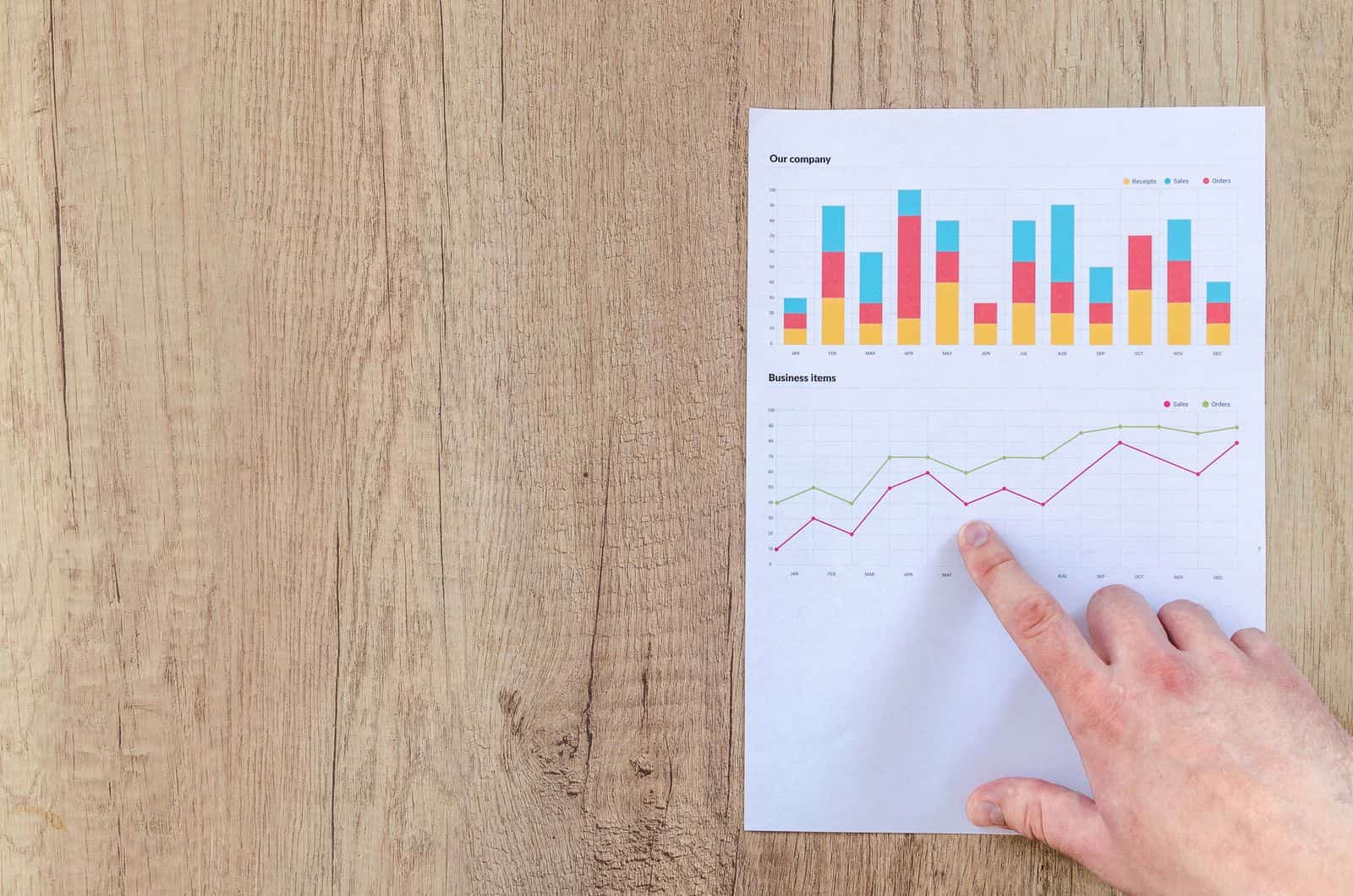 Main analysant des graphiques imprimés sur un bureau — l'examen des données d'un audit marketing